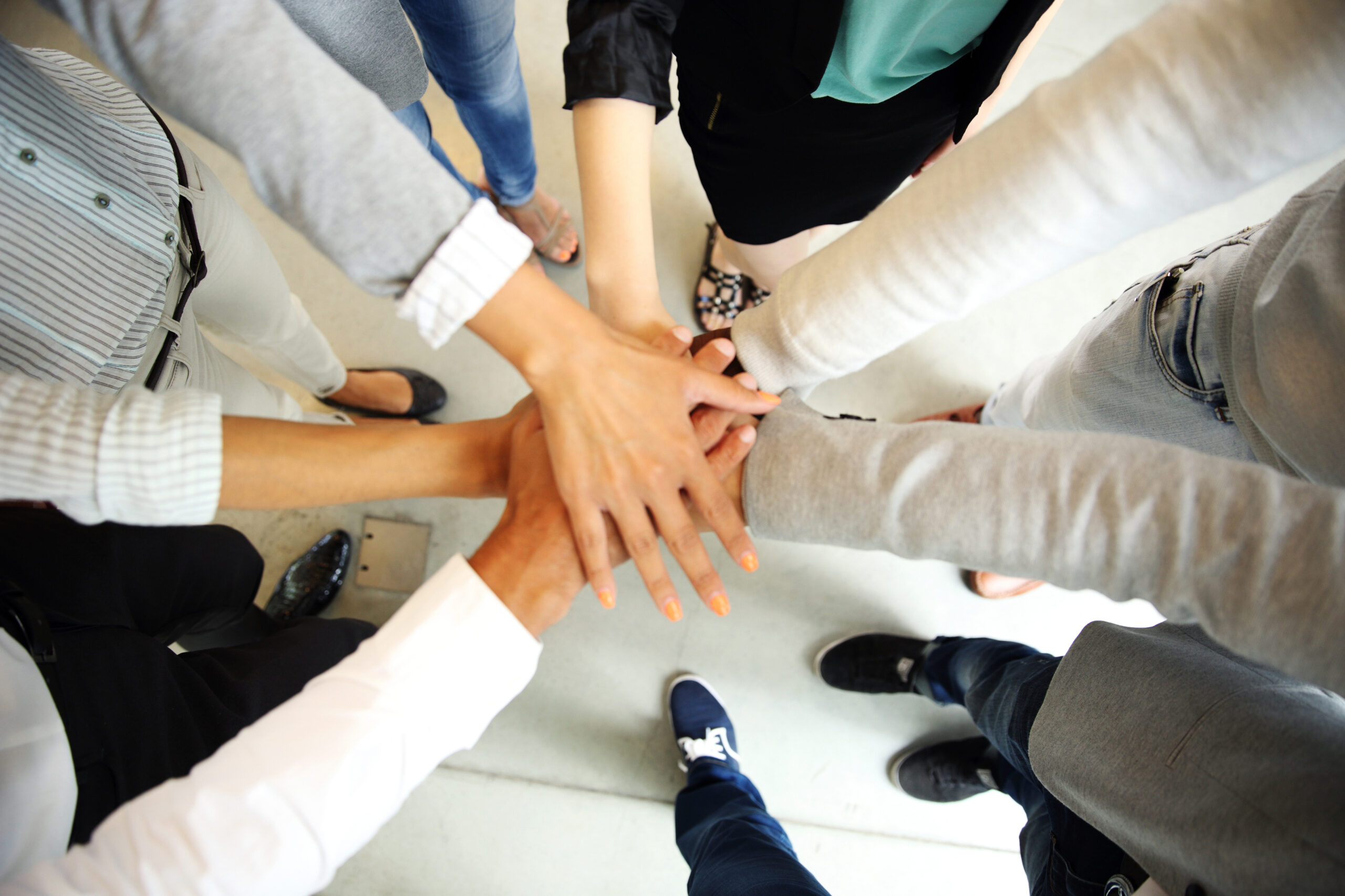 Nonprofit team members placing their hands together