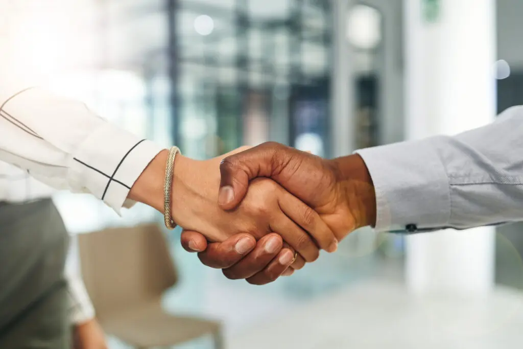 Two business professionals shaking hands in an office