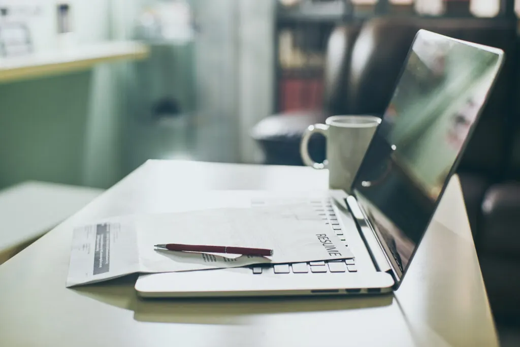 Laptop with printed documents and a pen on an office desk